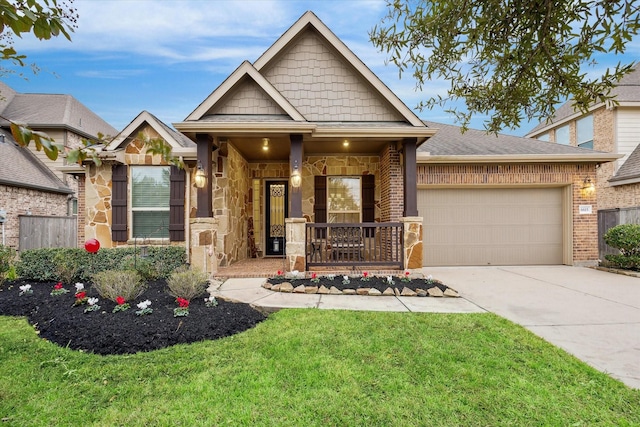 craftsman-style home with covered porch, a garage, and a front lawn