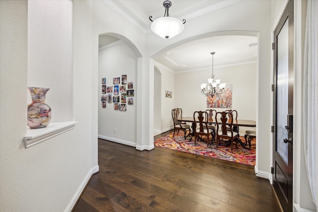 interior space with dark hardwood / wood-style flooring, ornamental molding, and a chandelier