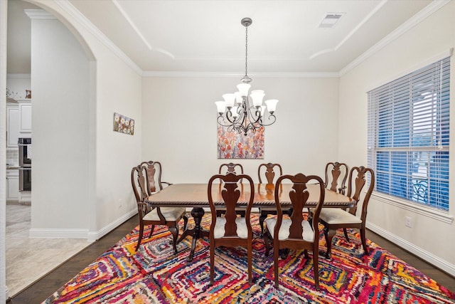 6615 Cottonwood Crest Ln, Katy, TX 77493 - dining area with arched walkways, a chandelier, a raised ceiling, baseboards, and crown molding
