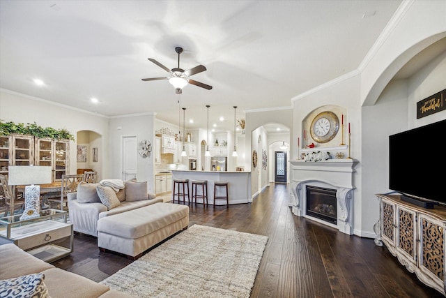 6615 Cottonwood Crest Ln, Katy, TX 77493 - living area with a ceiling fan, dark wood finished floors, a glass covered fireplace, arched walkways, and recessed lighting