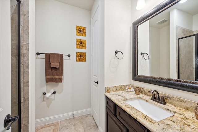 bathroom featuring a shower with door and vanity