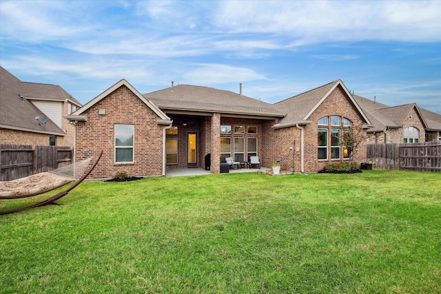 back of property with a yard and a patio