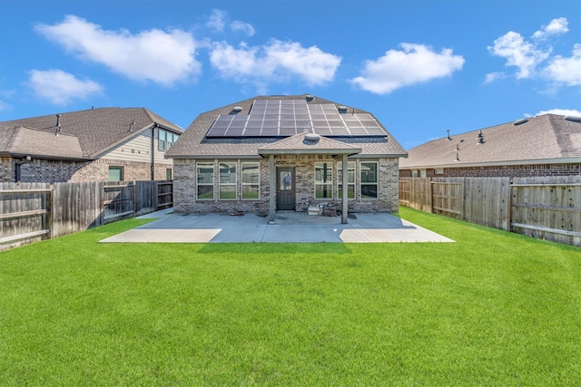 back of house with solar panels, a patio, and a yard