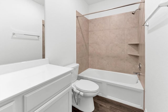 full bathroom with vanity, hardwood / wood-style flooring, toilet, and tiled shower / bath