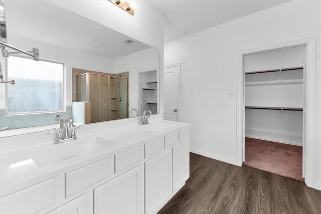 bathroom featuring hardwood / wood-style floors, vanity, and walk in shower