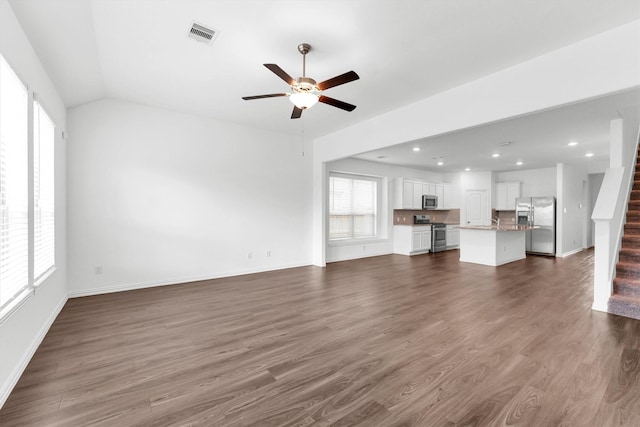 unfurnished living room featuring lofted ceiling, ceiling fan, and dark hardwood / wood-style floors