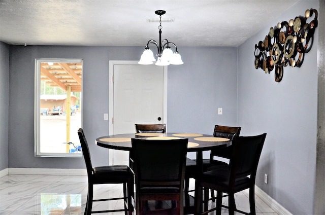 dining area with a textured ceiling and a chandelier