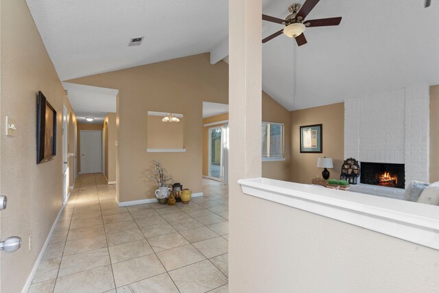 hall featuring light tile patterned flooring and lofted ceiling