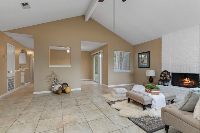 living room featuring beam ceiling, ceiling fan, a brick fireplace, high vaulted ceiling, and light tile patterned floors