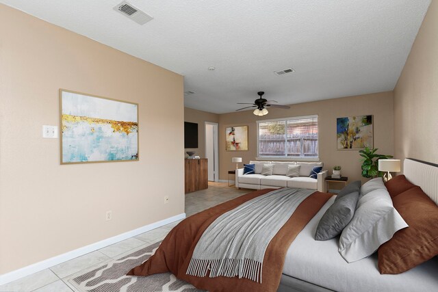 bedroom featuring ceiling fan, light tile patterned floors, and a textured ceiling