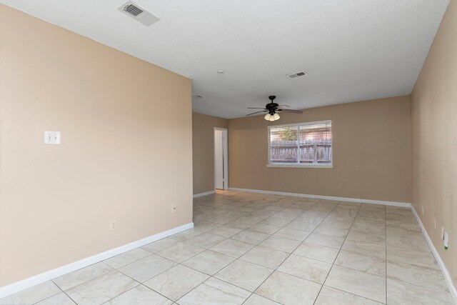 tiled empty room featuring ceiling fan and a textured ceiling