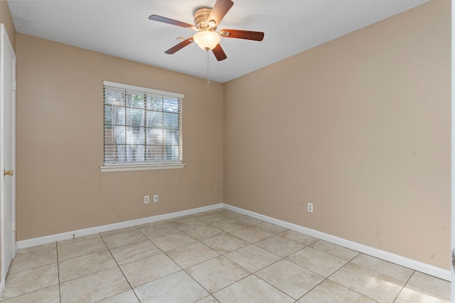 tiled empty room with ceiling fan and a textured ceiling