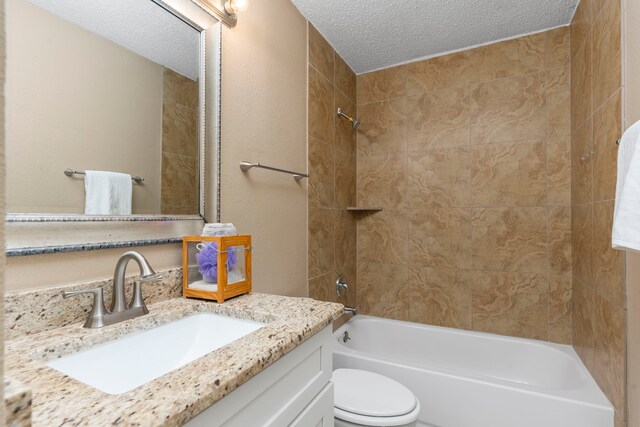 full bathroom featuring tiled shower / bath combo, toilet, a textured ceiling, and vanity