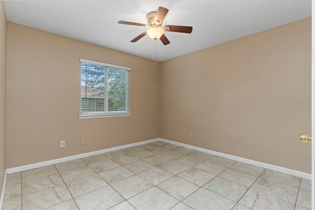 empty room featuring ceiling fan and a textured ceiling