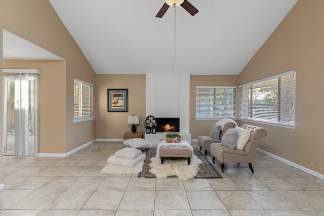 living room with a fireplace, light tile patterned floors, high vaulted ceiling, and ceiling fan