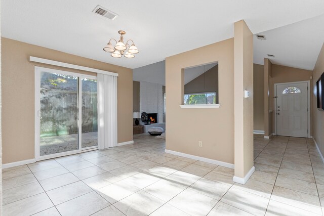 interior space with a chandelier, light tile patterned floors, and lofted ceiling