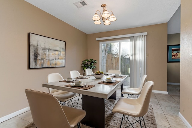 tiled dining room with a chandelier