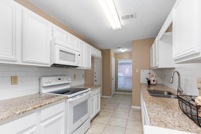 kitchen featuring light stone countertops, sink, backsplash, white appliances, and white cabinets