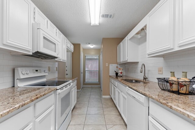 kitchen with white cabinets, white appliances, sink, and tasteful backsplash