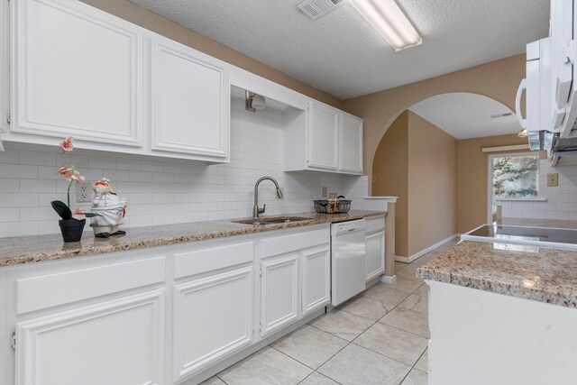 kitchen with white cabinets, dishwasher, sink, and backsplash