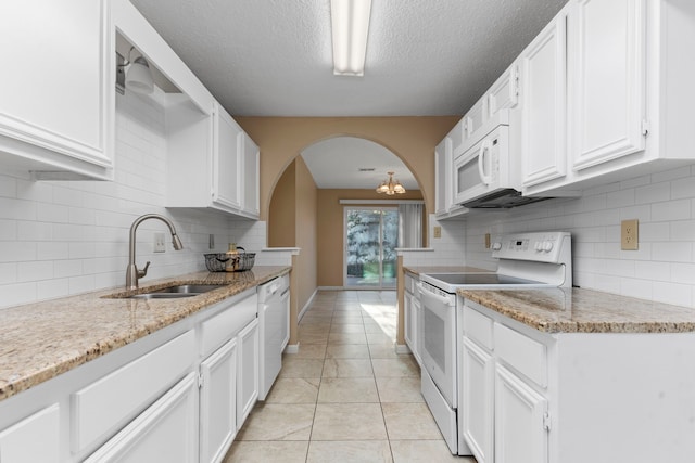 kitchen featuring white appliances, tasteful backsplash, white cabinetry, and sink