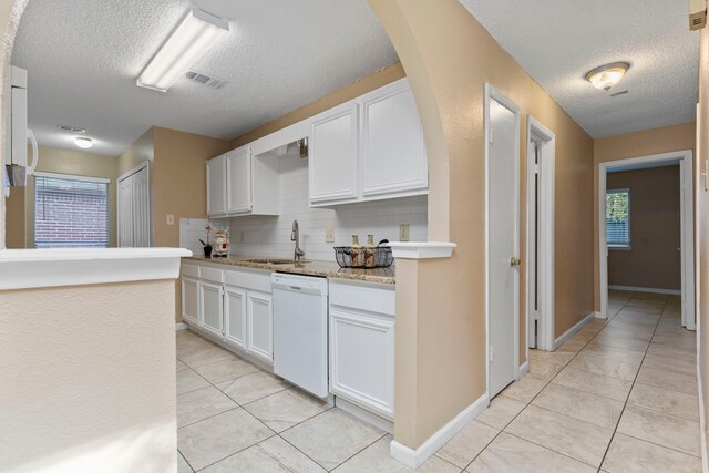 kitchen with decorative backsplash, dishwasher, white cabinets, and sink