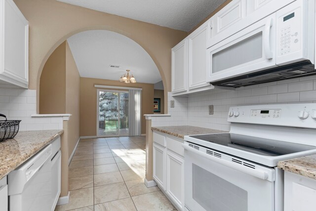 kitchen with white cabinets, white appliances, backsplash, and a chandelier