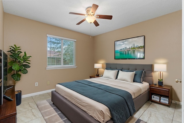 bedroom with ceiling fan and a textured ceiling