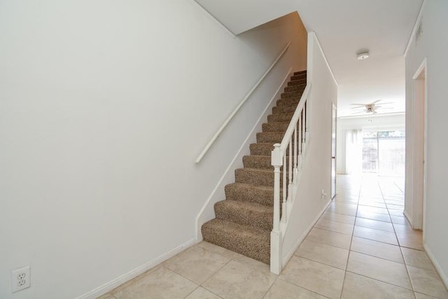 stairway featuring tile patterned flooring and ceiling fan