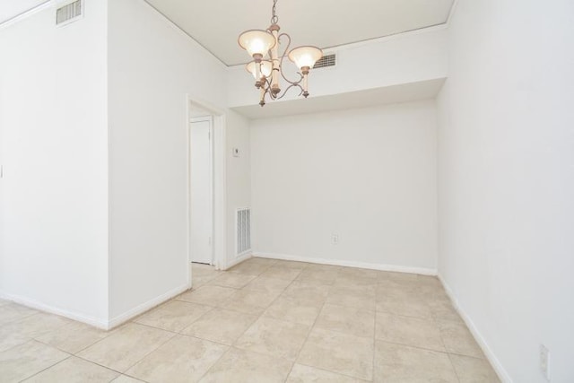 tiled spare room with an inviting chandelier