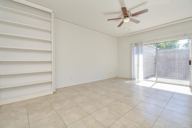 tiled empty room featuring ceiling fan