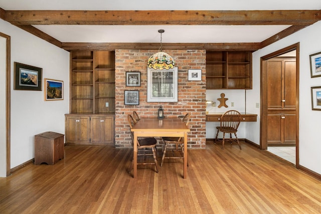 dining room with beamed ceiling and light wood-type flooring