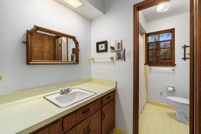 bathroom featuring tile patterned floors, vanity, and toilet