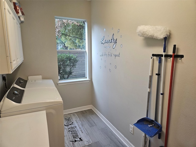 washroom featuring hardwood / wood-style flooring, cabinets, and separate washer and dryer