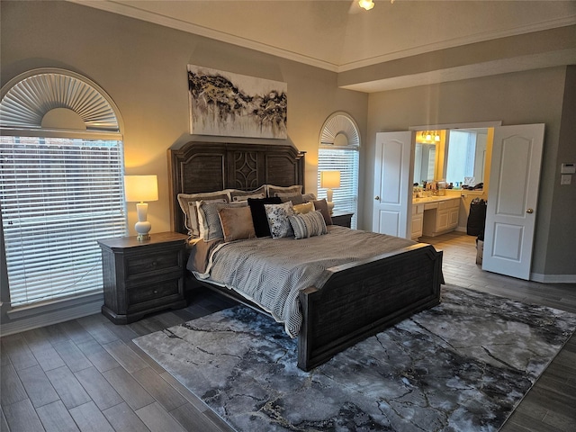 bedroom with hardwood / wood-style flooring and connected bathroom