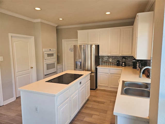 kitchen featuring white cabinetry, stainless steel refrigerator with ice dispenser, a center island, and sink