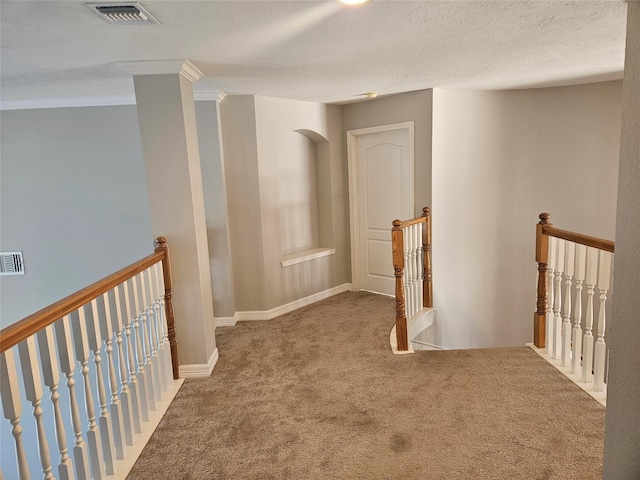 corridor featuring a textured ceiling and carpet flooring