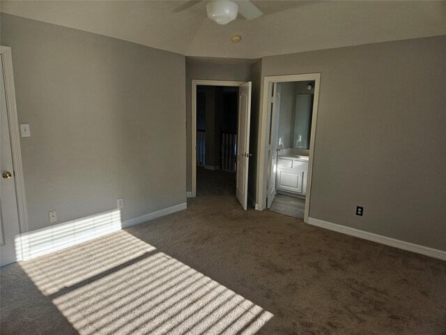 spare room featuring ceiling fan and dark colored carpet