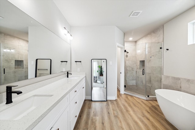 bathroom featuring hardwood / wood-style floors, vanity, and separate shower and tub