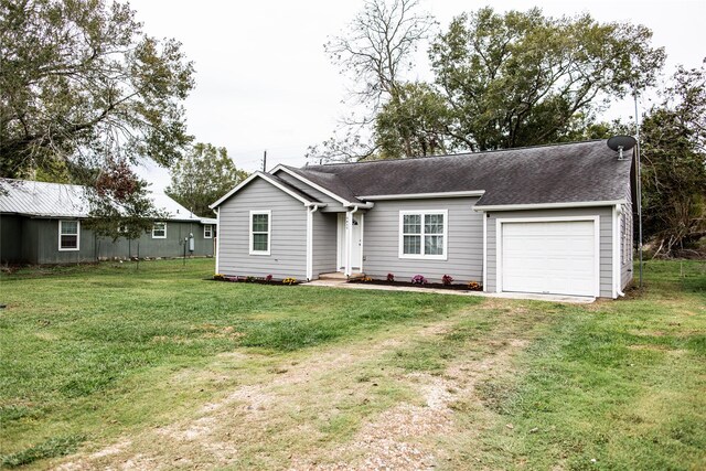 single story home featuring a garage and a front lawn