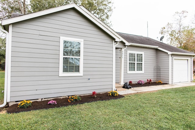 view of property exterior featuring a yard and a garage