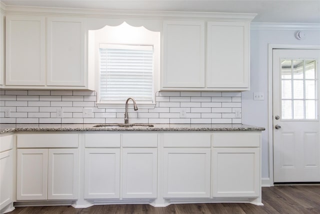 kitchen with sink, tasteful backsplash, white cabinets, and stone counters