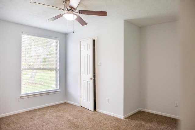 empty room with light colored carpet and ceiling fan