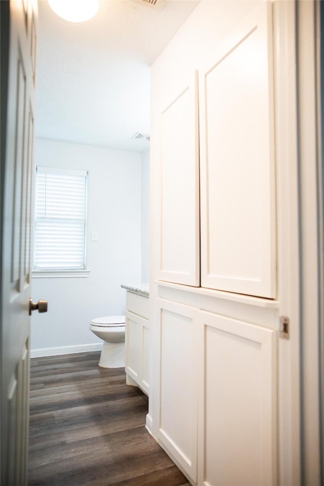 bathroom featuring vanity, toilet, and hardwood / wood-style floors