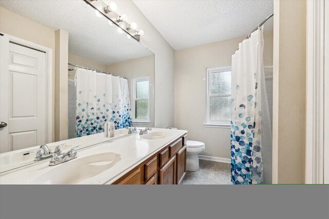 bathroom with vanity, toilet, a shower with shower curtain, and a textured ceiling