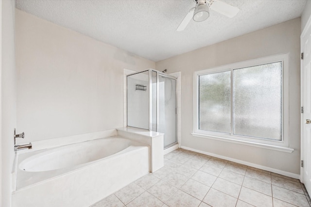 bathroom with a textured ceiling, a healthy amount of sunlight, and separate shower and tub