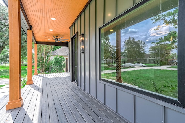 deck with a lawn, ceiling fan, and a porch