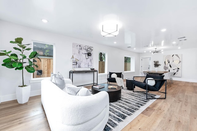 living room featuring light hardwood / wood-style floors and ceiling fan