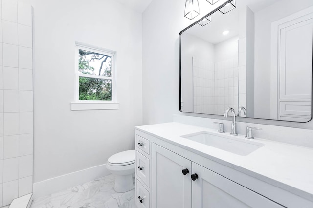 bathroom featuring tiled shower, vanity, and toilet