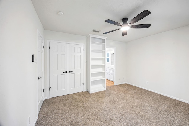 unfurnished bedroom featuring ceiling fan, a closet, and carpet